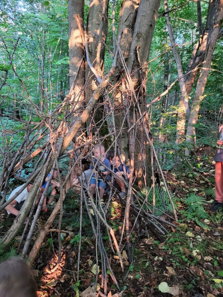 Dzieciaki w szałasie-leśen zajecia na rodzinnych wakacjach