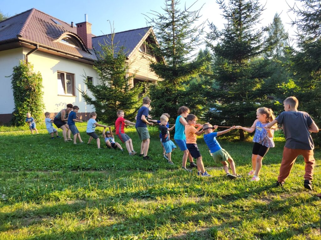 Dzieci przeciągają linę-wspólna zabawa na  rodzinnych wakacjach